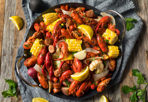 A vibrant seafood platter featuring crawfish, corn, and sausage