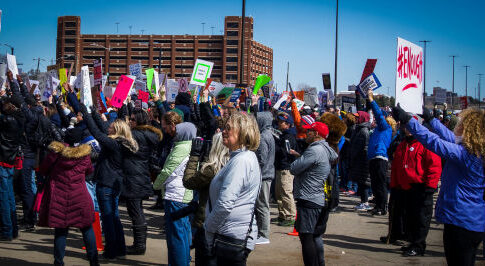 Large crowd of demonstrators holding signs at a protest