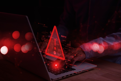 System,Hacked,Warning,Alert,On,Notebook,(laptop).,Cyber,Attack,On A person typing on a laptop with a red warning symbol overlay