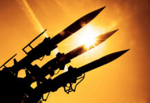 New Super-Missile Targets China’s Edge Silhouetted missiles on a launcher against a bright sunset sky