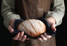Big Food Braces For California Chemical Gauntlet Person holding a freshly baked loaf of bread in a cloth