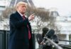 A man in a suit gesturing while speaking at a press conference outside the White House